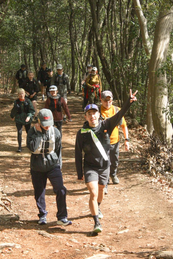 西岡賢一が先頭で手を上げながら仲間と走る