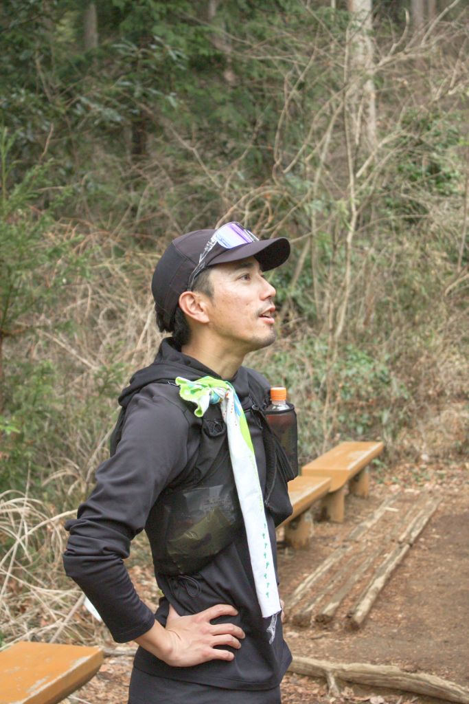 インストラクター 西岡賢一 森の中で空を見上げる